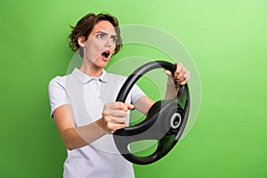 Photo of angry young girl stupor watching crime situation on road driving steering wheel automobile isolated over green