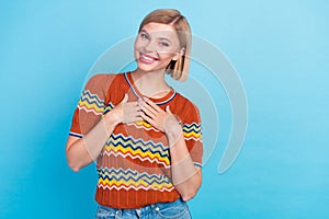 Photo of appreciative nice girlish woman with bob hairdo dressed knitwear t-shirt keep palms on chest isolated on blue photo