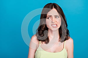 Photo of arrogant moody girl dressed green clothes biting lip looking empty space isolated blue color background