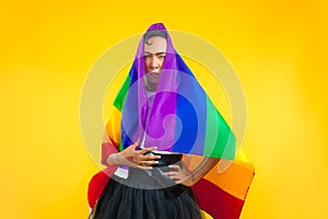 Photo of asian gay with pride movement LGBT Rainbow flag isolated yellow background. Man with a gay pride flag