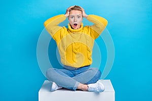 Photo of astonished anxious embarrassed lady sitting platform impressed bad news negative information isolated on blue