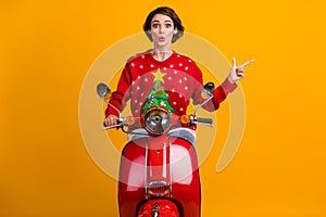 Photo of astonished girl drive ride red scooter point index finger miracle x-mas eve time promo wear christmas tree