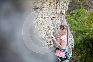 Photo of athlete girl clambering over rock photo