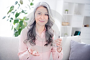 Photo of attractive aged woman happy positive smile drink water pills vitamins health care meds home