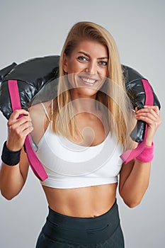 Photo of attractive blonde woman doing training with sandbag