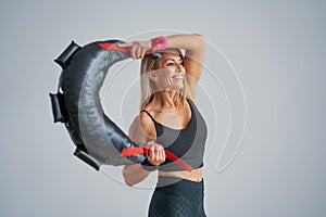 Photo of attractive blonde woman doing training with sandbag