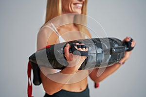 Photo of attractive blonde woman doing training with sandbag