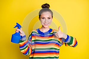Photo of attractive brunette bun young woman hold pulverizer show thumb up recommend product isolated on yellow color