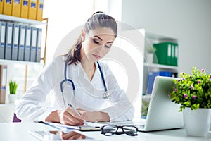 Photo of attractive concentrated female doctor writing prescript