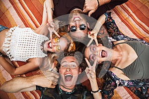 Photo of attractive hippies guys and girls laughing, and lying o