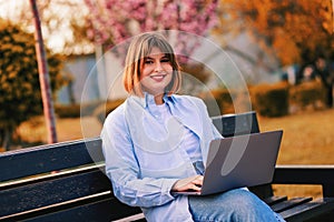 Photo of attractive lady student sit on bench in green park browsing notebook chatting friends do home tasks inspiration nature