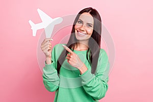 Photo of attractive latin young lady wear green trendy shirt demonstrate finger paper aircraft lowcost flights isolated photo