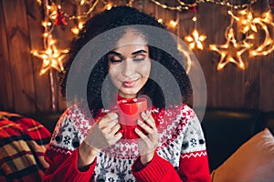 Photo of attractive positive girl closed eyes smell fresh aroma coffee mug christmas festive decoration lights flat