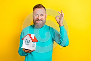 Photo of attractive retired man wear stylish clothes hand okey deal recommend buy real estate isolated on yellow color