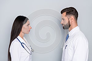 Photo of attractive smart two docs dressed white uniform looking each other isolated grey color background
