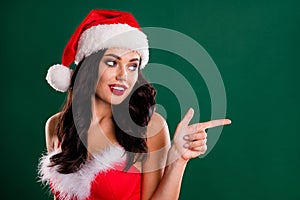 Photo of attractive snow lady look direct finger empty space promo x-mas cap isolated on green color background