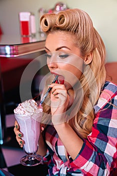 Photo of attractive surprised woman drinking milkshake