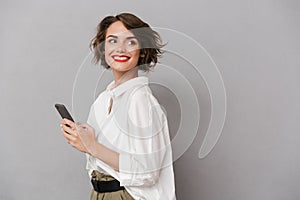 Photo of attractive woman 20s smiling and holding mobile phone