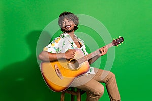 Photo of attractive young man sit chair look empty space guitarist dressed stylish citrus print clothes isolated on