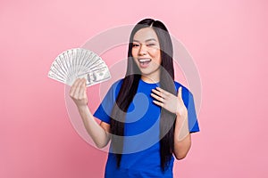 Photo of attractive young positive charming woman hold hands money smile isolated on pink color background