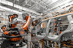 Photo of automobile production line. Welding car body. Modern car assembly plant. Auto industry. Interior of a high-tech
