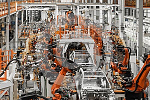 Photo of automobile production line. Welding car body. Modern car assembly plant. Auto industry. Interior of a high-tech