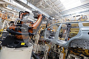 Photo of automobile production line. Welding car body. Modern car assembly plant. Auto industry. Interior of a high-tech