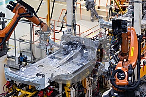 Photo of automobile production line. Welding car body. Modern car assembly plant. Auto industry. Interior of a high-tech