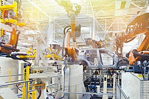 Photo of automobile production line. Welding car body. Modern car assembly plant. Auto industry. Yellow tone
