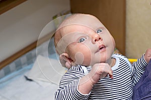 Photo of baby with big blue eyes, which is held by mother