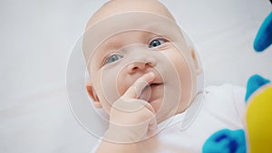 Photo of baby four month girl with fingers in mouth