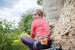 Photo from back of smiling sportswoman climbing woman sitting next to mountain