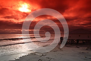 Photo of beach and ocean with sun using a red fliter.