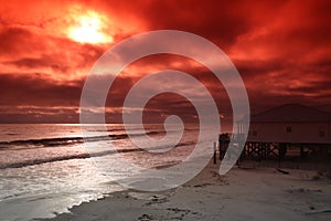 Photo of beach and ocean with sun using a red fliter. photo