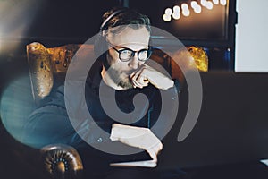 Photo bearded businessman wearing glasses relaxing modern loft office.Man sitting in vintage chair,listening music