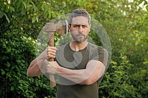 photo of bearded masculine guy hold sharp axe outdoor
