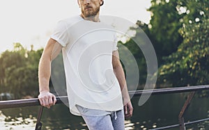 Photo Bearded Muscular Man Wearing White Empty t-shirt, snapback cap and shorts in summer holiday. Relaxing time near