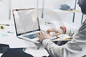 Photo bearded project manager working new startup modern loft. Using contemprary laptop with reflections screen on wood