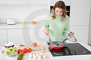 Photo of beautiful cheerful housewife watch frying pan checking mushrooms meal condition cooking tasty dinner lunch