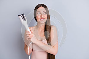 Photo of beautiful model lady long hairstyle hold electric styler curler making straight curls wavy look up empty space