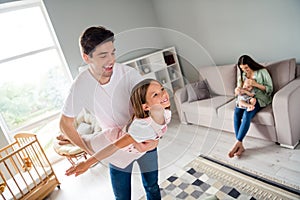 Photo of beautiful peaceful family father play flight daughter mother sit sofa embrace son house indoors