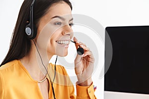 Photo of beautiful phone operator woman wearing microphone headset sitting in office and speaking with client