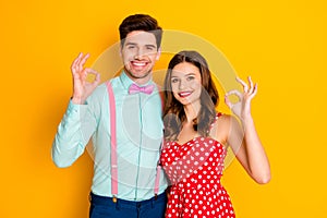 Photo beautiful pretty lady handsome guy toothy smiling prom couple showing okey symbols hands wear red dotted dress