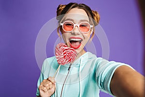 Photo of beautiful woman 20s with hair in buns holding big candy