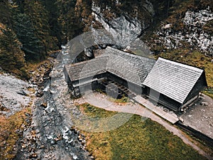 Fotografie krásné dřevěné chaty s řekou v lese shora - Mlyny Oblazy Slovensko - pořízená dronem. Starý dřevěný mlýn