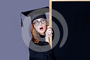 photo of beautiful young alumnus with blackboard on the wonderful grey studio background photo