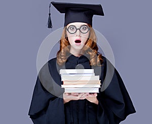 photo of beautiful young alumnus with pile of books on the wonderful grey studio background photo