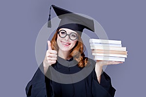 photo of beautiful young alumnus with pile of books on the wonderful grey studio background photo