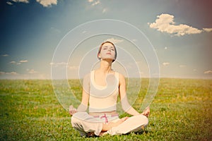 Photo of beautiful young woman doing joga and relaxing on the wo