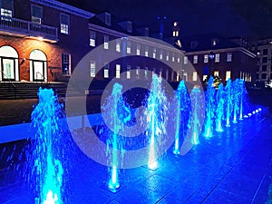 Big Building and Blue Water Jet Fountain at Night photo
